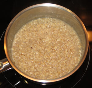 Porridge auf der Herdplatte - aufkochen und köcheln + ziehen lassen.
